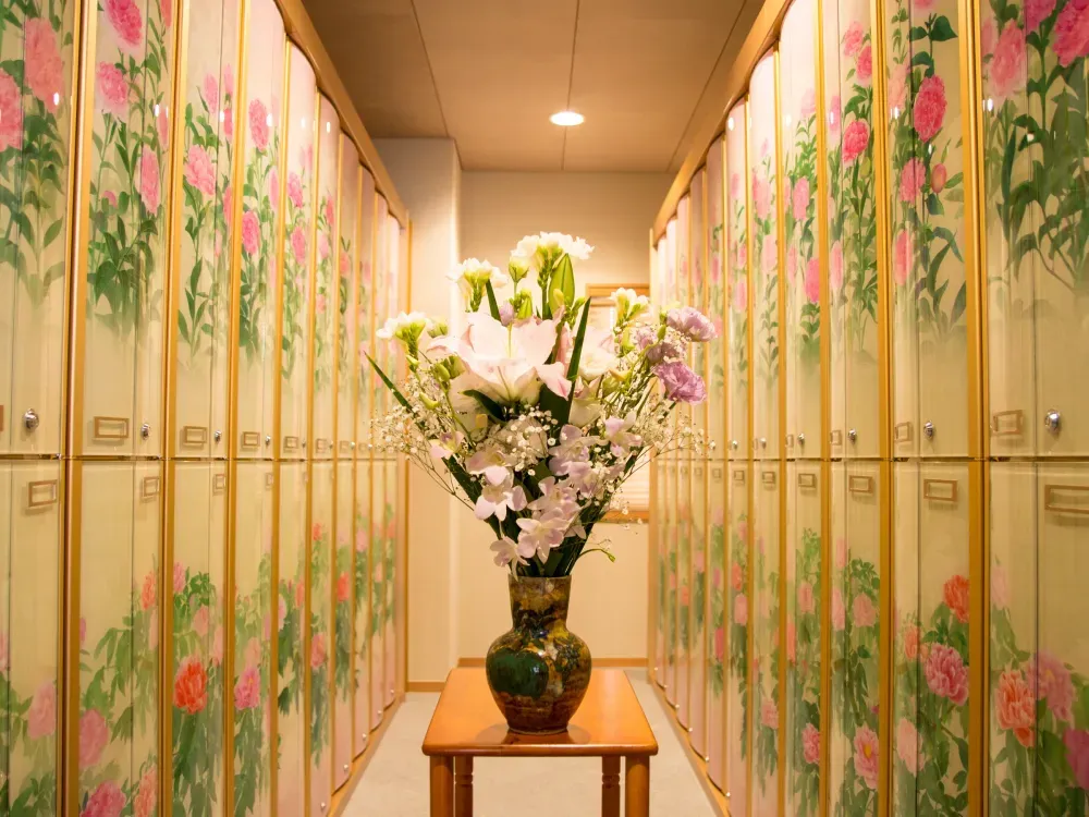 花の絵柄の納骨壇が並ぶ通路と献花